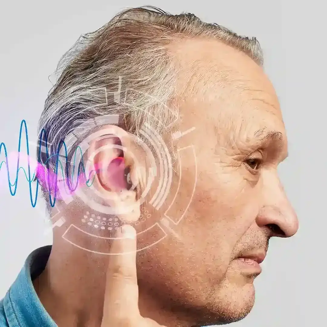 Profile of an older man adjusting a discreet in-ear hearing aid